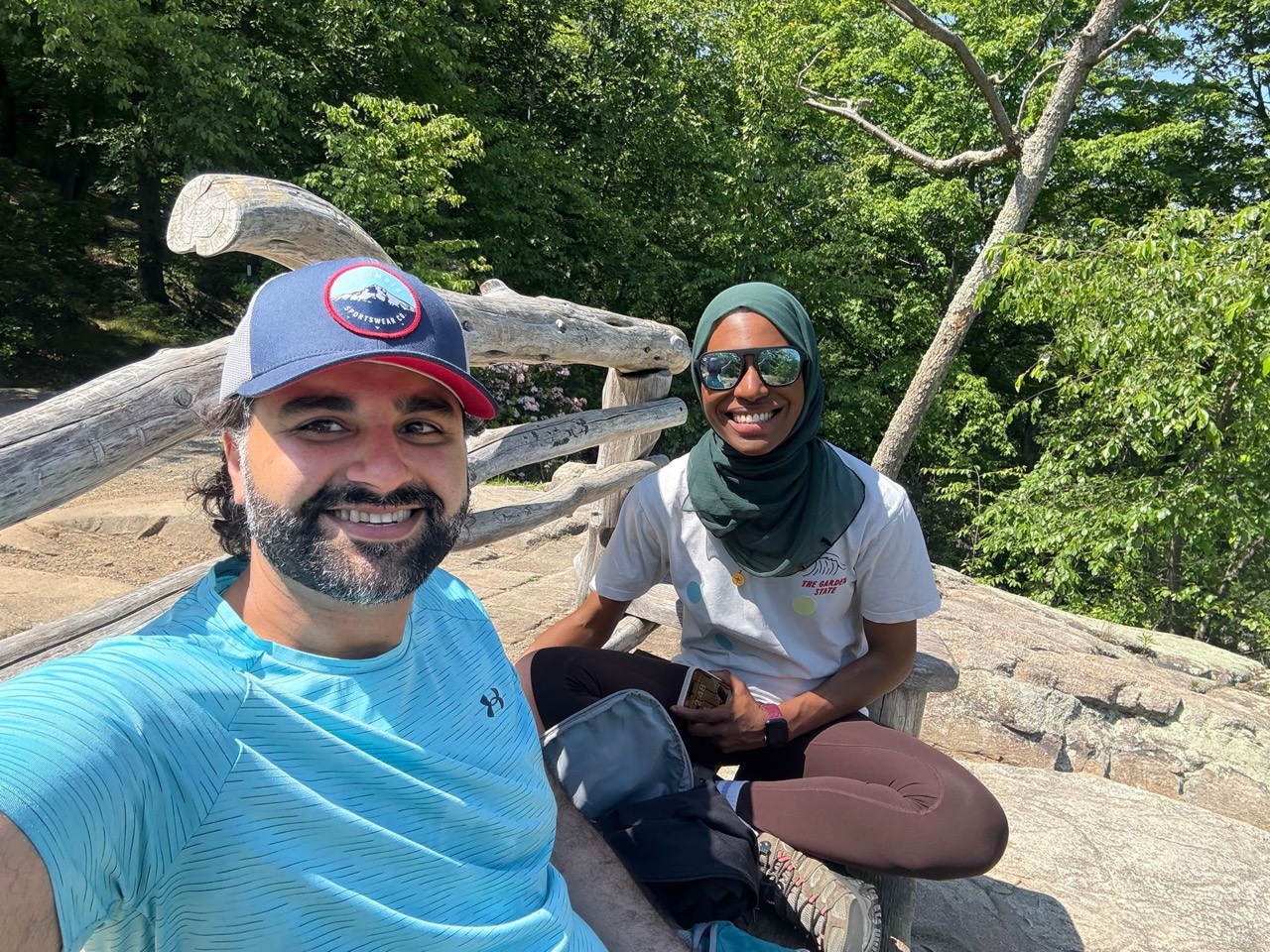 Amal and Usman smiling together on a sunny hiking day